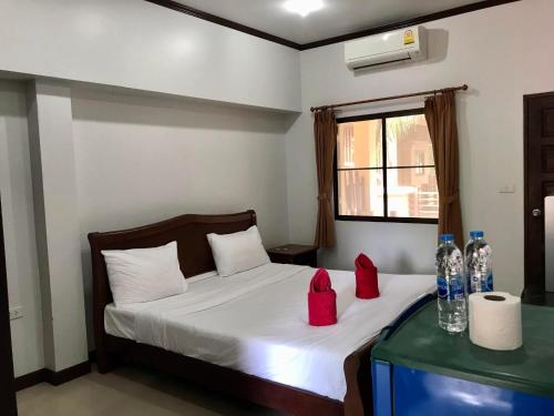 a bedroom with a bed with red boxes on it at TandT House in Lamai