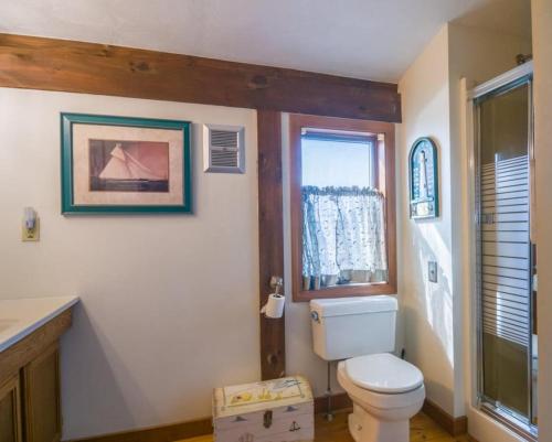 a bathroom with a toilet and a window at 53 Freeman Avenue Sandwich - Cape Cod in Sandwich
