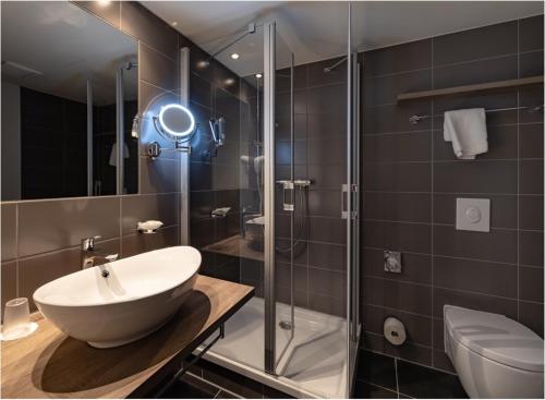 a bathroom with a sink and a glass shower at Santé Royale Rügen Resort in Göhren
