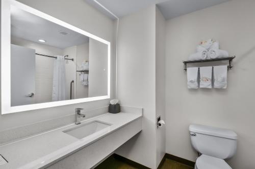 Baño blanco con lavabo y espejo en Holiday Inn Express Hotel & Suites Lucedale, an IHG Hotel, en Lucedale