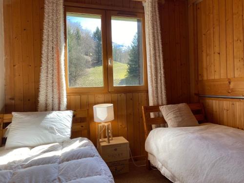 a bedroom with two beds and a window at Chalet Savoyard avec Cheminée et Parking à Samoëns - FR-1-624-80 in Samoëns