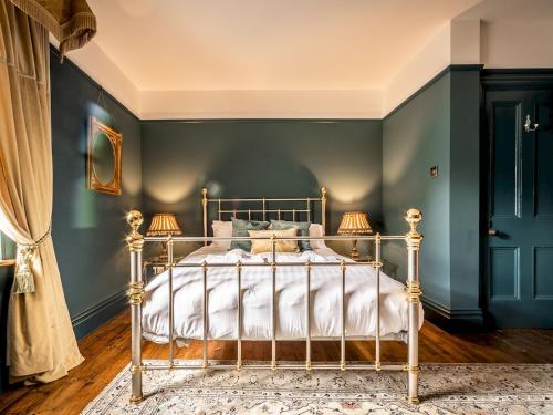 a bedroom with a bed with blue walls and a rug at Pass the Keys Characterful period home in heart of Chagford in Chagford