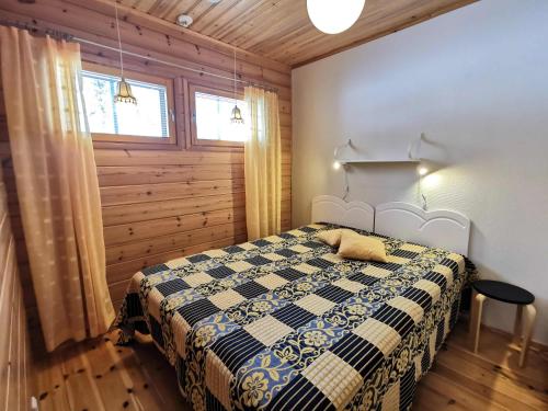 1 dormitorio con 1 cama en una habitación con paredes de madera en Kärpänpesä B en Syöte