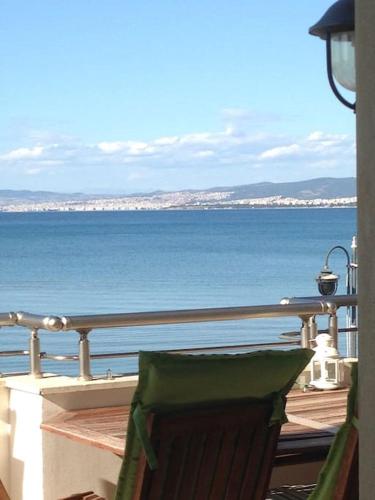 a chair sitting on a balcony looking at the ocean at Sea and Sun Luxury apartment in Neoi Epivates