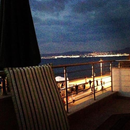 a chair sitting on top of a balcony overlooking the ocean at Sea and Sun Luxury apartment in Neoi Epivates