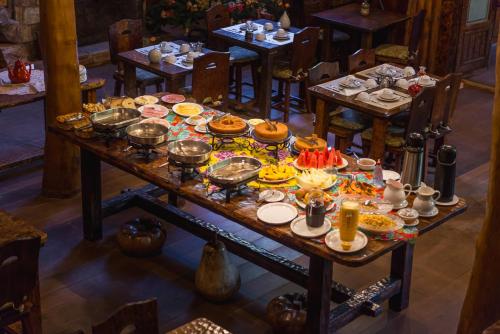 a table with many plates of food on it at Hotel Fazenda Itapuá in Monte Verde