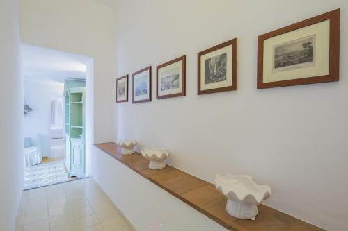 un pasillo con 2 sillas blancas en la pared en Estate4home - Villa San Montano, en Massa Lubrense