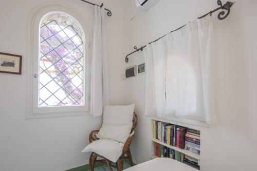 1 dormitorio con silla y ventana en Estate4home - Villa San Montano, en Massa Lubrense
