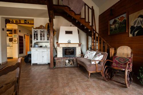 a living room with a fireplace and a chair at Modryna Ranczo in Krasiczyn