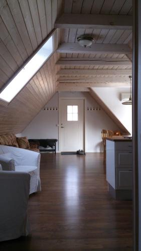 SkillingarydにあるLoft Ålarydのベッドとテーブルと窓のある屋根裏部屋