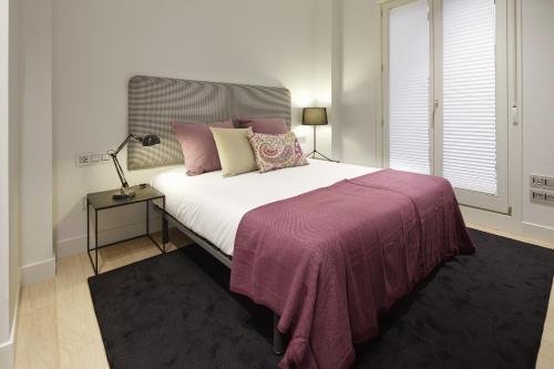 サン・セバスティアンにあるEaso Suite 1 by FeelFree Rentalsのベッドルーム(紫の毛布を使用した大型ベッド1台付)