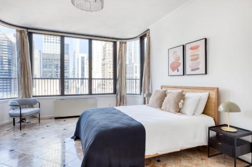 a bedroom with a large white bed and large windows at Midtown East 3BR w Doorman Gym nr Bloomingdales NYC-915 in New York