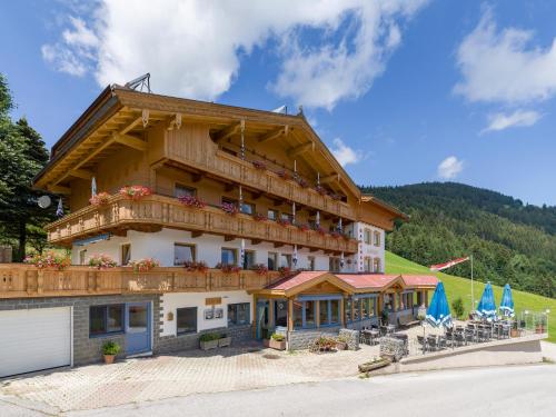a large building with a balcony with chairs and umbrellas at Gasthof Schöntal in Oberau