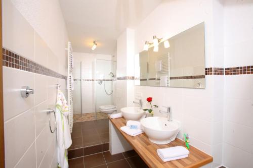 a white bathroom with two sinks and a mirror at Landhotel Salmen in Oberkirch