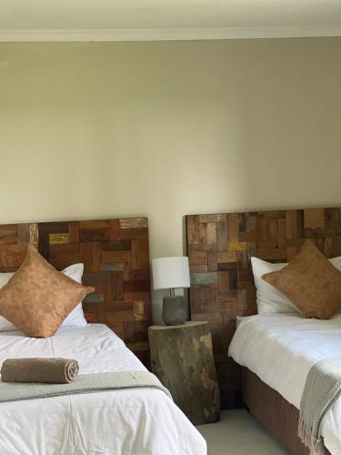 two beds sitting next to each other in a bedroom at Rosetta Fields Country Lodge in Henburg Park