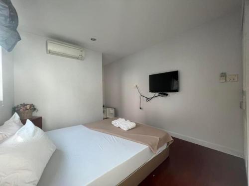 ein Schlafzimmer mit einem Bett und einem TV an der Wand in der Unterkunft Se'sun Amphawa in Amphawa