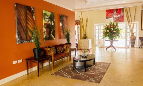 a living room with orange walls and furniture and plants at Bay Gardens Beach Resort & Spa in Gros Islet