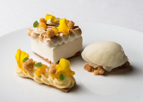 un morceau de gâteau et de crème glacée sur une assiette blanche dans l'établissement Hotel restaurant au gourmet, à Drusenheim