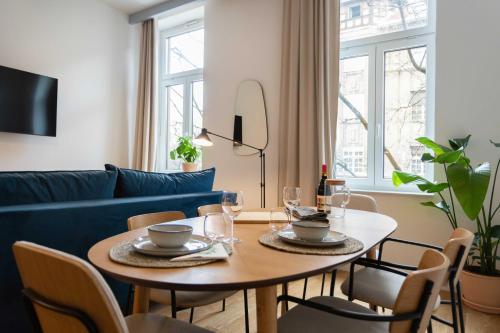 - un salon avec une table et un canapé bleu dans l'établissement Design Apartments near Botanical Garden, à Zagreb