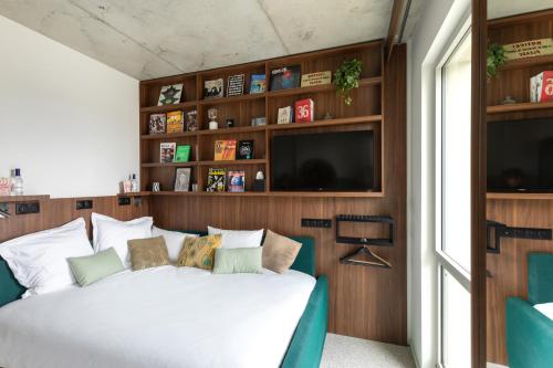 a bedroom with a white bed and a tv at JOST Hôtel Bordeaux Centre Gare Saint Jean in Bordeaux