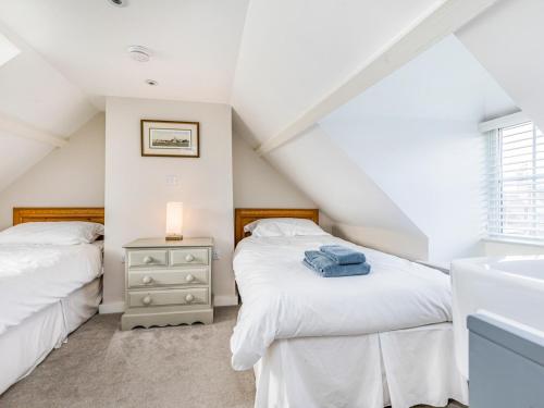 two beds in a attic bedroom with a sink at Pass the Keys Charming Cottage 1 Min Walk from Wareham Quay in Wareham
