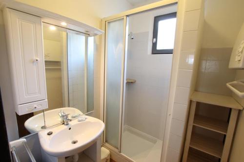 La salle de bains est pourvue d'un lavabo blanc et d'une douche. dans l'établissement Chez frutos, à Vielleségure