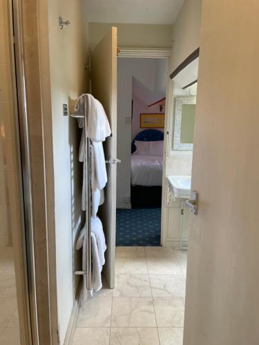 a bathroom with a door open to a room with a bed at Langrish House in Petersfield