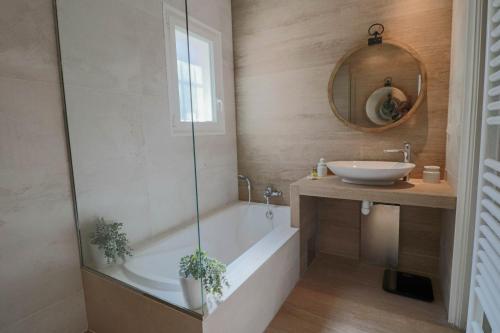 une salle de bain avec une baignoire, un lavabo et un miroir dans l'établissement VILLA DES COLLINES - Absolute calm at 10' from the center, à Antibes