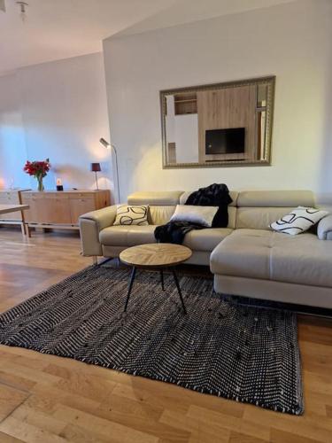 a living room with a couch and a table at Accueillant et pratique, proche de Chantilly et du parc Asterix in Lamorlaye