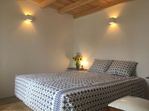 ein Schlafzimmer mit einem Bett und zwei Lampen an der Wand in der Unterkunft A casinha in Encarnação