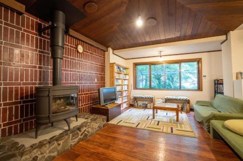 a living room with a fireplace and a couch at Sounkyo Hostel in Kamikawa