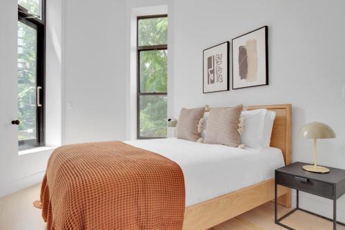 a white bedroom with a bed and two windows at Cobble Hill 3BR w WD nr Carroll Park NYC-885 in Brooklyn
