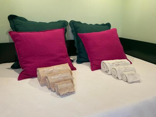 a bed with two pink pillows and towels on it at Studio by Casa da Quinta in Funchal