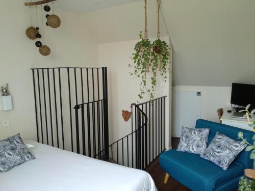1 dormitorio con 1 cama y 1 sofá azul en Charmant logement vue mer avec chambre et terrasse, en Guidel