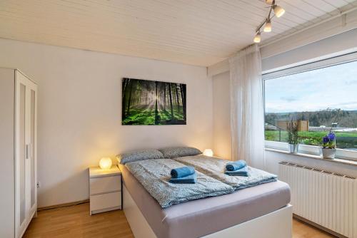 een slaapkamer met een bed en een groot raam bij Wächtersberg in Wildberg
