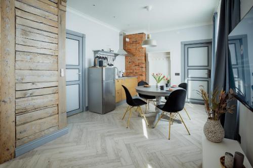 a kitchen and dining room with a table and chairs at UUE TÄNAVA KORTER in Kuressaare
