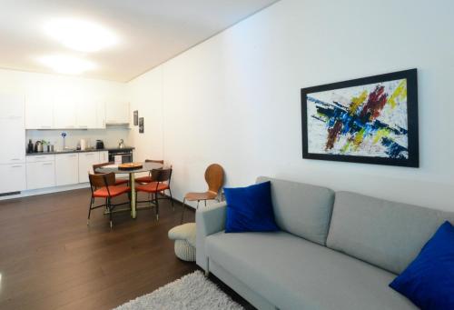 een woonkamer met een bank en een tafel bij Brand-New, Close to Centre, Rooftop-Summer-Pool in Wenen