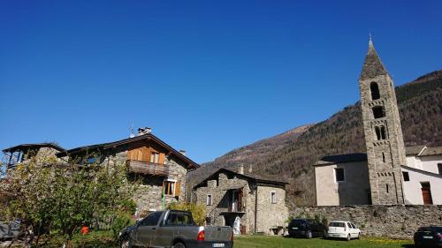 an old stone church with a tall tower and a church at Casa delle Rose in Teglio