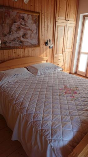 a large bed in a bedroom with a window at Casa delle Rose in Teglio