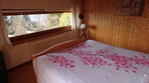 Un dormitorio con una cama con flores rosas. en Casa delle Rose, en Teglio