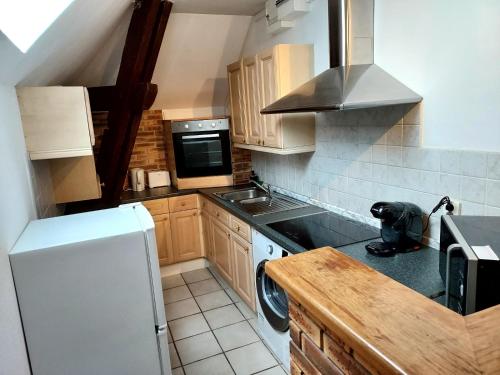 uma cozinha com um frigorífico branco e um fogão em A 2 pas de la gare em Châlons-en-Champagne