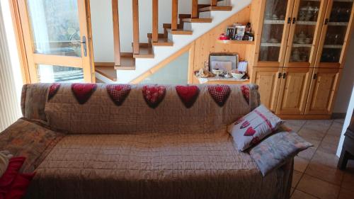 a couch in a living room with a staircase at Casa delle Rose in Teglio