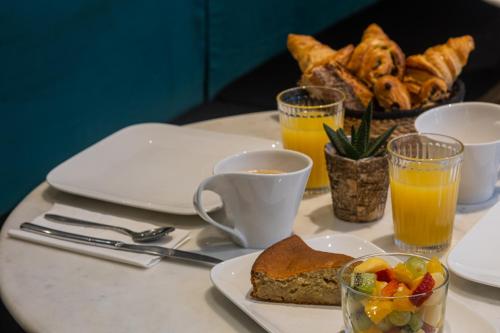 a white table with a plate of food and drinks at Hôtel Bristol Union Intra Muros in Saint Malo