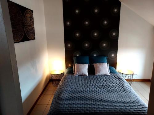 um quarto com uma cama com uma cabeceira preta e 2 candeeiros em A 2 pas de la gare em Châlons-en-Champagne