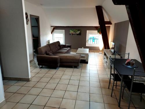 ein Wohnzimmer mit einem Sofa und einem Tisch in der Unterkunft A 2 pas de la gare in Châlons-en-Champagne