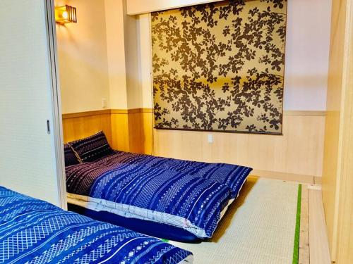 a bedroom with a bed and a painting on the wall at MoRi House IN 伊勢佐木町 in Yokohama