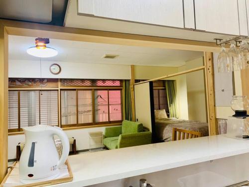 a kitchen with a mirror and a room with a couch at MoRi House IN 伊勢佐木町 in Yokohama