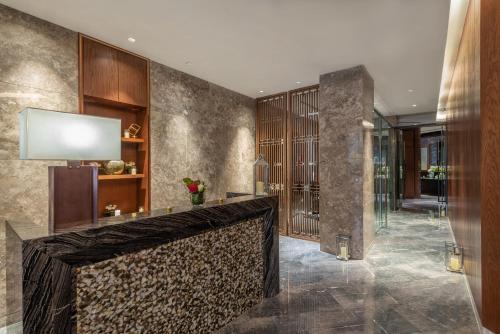 a lobby with a stone wall and a reception desk at Narcissus Obhur Resort & Spa in Jeddah