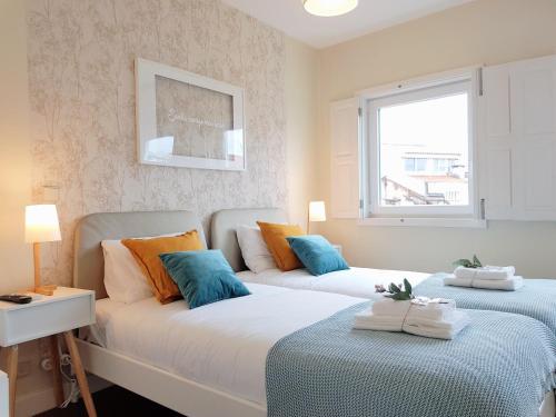 a bedroom with two beds and a window at Braga Bells Guesthouse in Braga