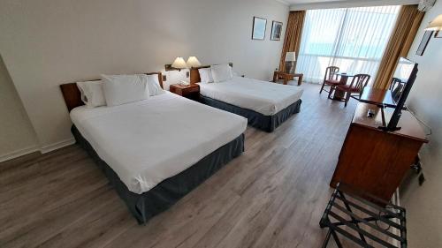 um quarto de hotel com duas camas e uma mesa em Hotel Diego De Almagro Costanera - Antofagasta em Antofagasta